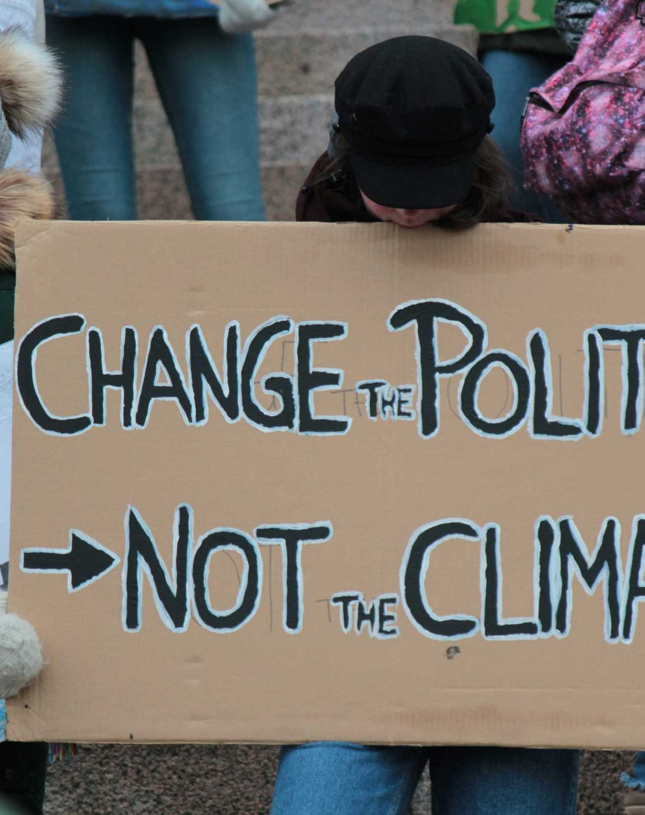 Protest sin on cardboard stating Change the Politics not the Climate
